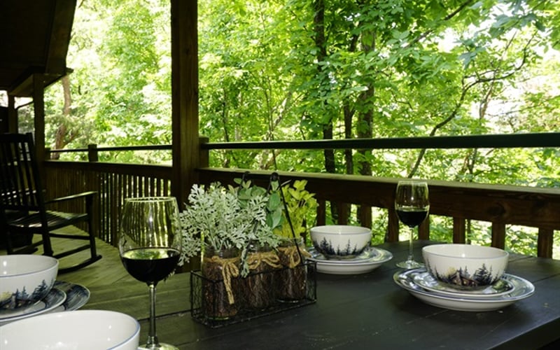 Perched amidst a lush canopy of towering trees, This private deck features an elegant outdoor dining setup that feels like a secluded woodland sanctuary.  It's the ultimate hidden gem for savoring a morning coffee or dinner enveloped by nature.
