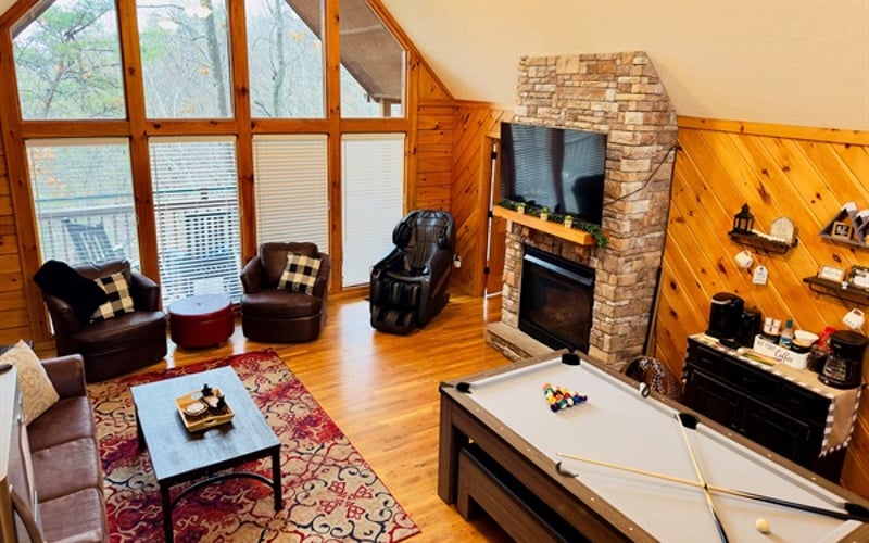 Escape to a bright, sun-drenched family room where floor-to-ceiling views of peaceful, wooded mountains create a breathtaking natural backdrop. This is the heart of your vacation home!  Relax, Dine, and play. 